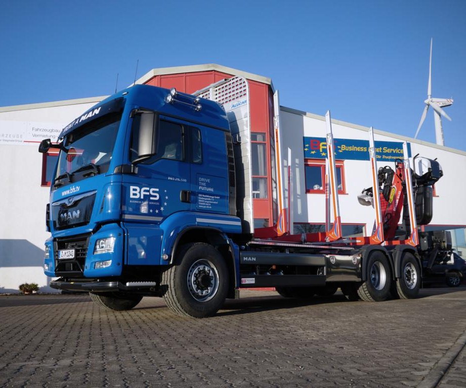 blauer MAN Holztransporter mit Palfinger Ladekran